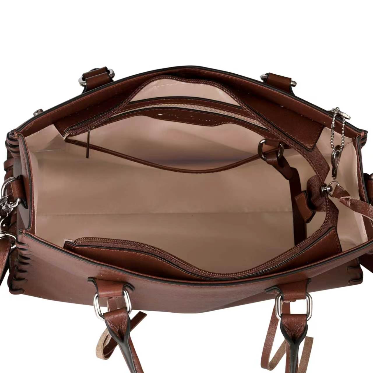 Open view of a brown leather handbag showing the interior compartments, beige lining, zipper pockets, and metal hardware on a white background.